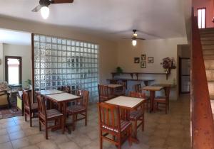 a restaurant with tables and chairs in a room at Pousada Mar Azul in Ubatuba