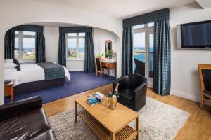 a hotel room with a bed and a living room at Atlantic Hotel Newquay in Newquay