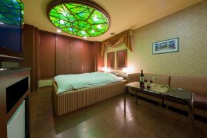a bedroom with a bed and a stained glass window at Hotel ニャンだふる in Himeji