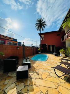 a backyard with a swimming pool and a palm tree at Pousada Mar Azul in Ubatuba