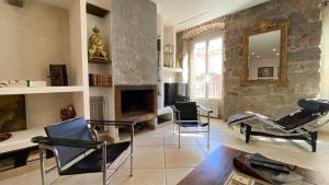 a living room with chairs and a table and a tv at CASA DI ARTISTI AJACCIO - Holiday Homes - Classé 5 étoiles - EXCEPTIONNEL in Ajaccio