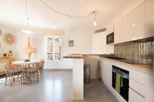 a kitchen with white cabinets and a table and chairs at Matelotte in Saint-Tropez