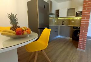 eine Küche mit einem Tisch und einer Obstschale darauf in der Unterkunft Apartmani Omrčen in Baška Voda