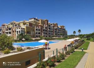 Il offre une vue sur un grand complexe d'appartements doté d'une piscine. dans l'établissement WIFI Los Cisnes 2 dormitorios Primera Linea playa Ayamonte Isla Canela, à Isla Canela