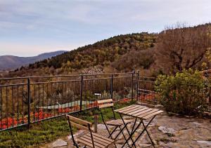 two benches and a table on a balcony with a mountain at Il Podere di Massi in Barberino di Mugello