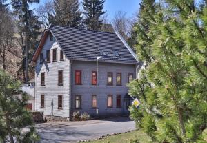 a large white house with a gambrel roof at Familienferienhaus "Zur Alten Wäscherei" in Schmiedefeld am Rennsteig