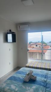 - une chambre avec un lit et une grande fenêtre dans l'établissement Pousada Ventura, à Anchieta