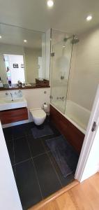 ein Bad mit einer Dusche, einem WC und einem Waschbecken in der Unterkunft Bright & spacious Double Bedroom with EnSuite and Concierge! Paid parking available in London