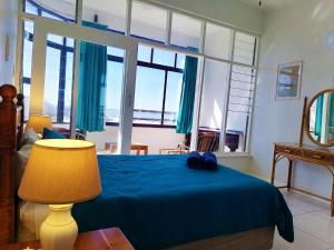 a bedroom with a blue bed and a large window at Claridges 104 in Margate