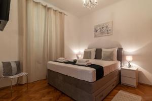 a bedroom with a large bed and a chandelier at Apartment Silvia in Trogir