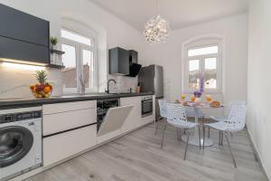 a white kitchen with a table and chairs in it at Apartment Silvia in Trogir
