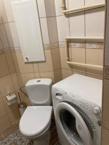 a bathroom with a toilet and a washing machine at Baltic Sea Beach Apartment in Liepāja