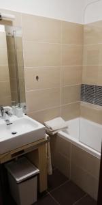 a bathroom with a sink and a tub and a toilet at Oliver apartmán 6 in Štrbské Pleso