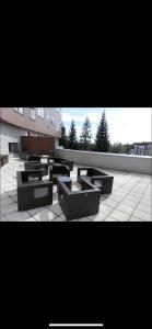 a group of benches on a courtyard with a building at Oliver apartmán 6 in Vysoke Tatry - Strbske Pleso