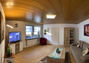 a living room with a couch and a tv at Ferienhaus Wolle & Beate in Alken +8 photos