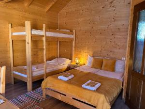 a bedroom with two bunk beds in a log cabin at Riverside Woodhouses in Praid