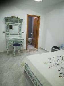 a bedroom with a bed and a dresser with a television at Belle Villa Proche Marina in Houmt Souk