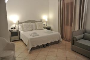 a bedroom with a bed and a couch and a chair at Relais Fenicottero Rosa in Porto San Paolo