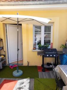 un paraguas en un césped frente a una casa en Maison d'une chambre avec jardin clos et wifi a Brevonnes, en Brévonnes
