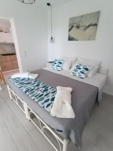 a large bed with blue and white pillows on it at Kiki's Apartments in Barbati