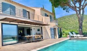 a villa with a swimming pool next to a house at Découvrez la Villa « The View » in Cavalaire-sur-Mer