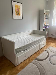 a bed with a white bed frame in a room at Pálma apartman in Szentes +4 photos