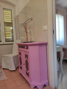 a pink cabinet with a vase on top of it at Hotel Glicine in Noli +61 photos