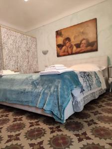 a bedroom with a bed with a painting on the wall at Hotel Glicine in Noli
