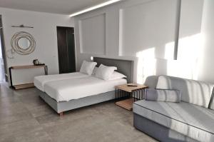 a hotel room with a bed and a couch at Smy Bellevue Mykonos in Tourlos