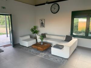a living room with a white couch and a clock at La Estación in San Asensio