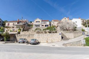 two cars parked in front of a stone wall at Apartments Goran in Postira