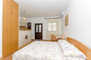a bedroom with a large bed and a kitchen at Apartments Goran in Postira
