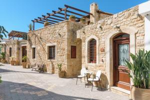 een stenen huis met een tafel en stoelen op een patio bij Casa Di Veneto in Chersonissos