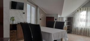 a dining room with a table and chairs and a television at Pensiunea Alessia in Piatra Neamţ
