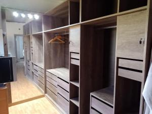 ein begehbarer Kleiderschrank mit Holzschränken und einem Fernseher in der Unterkunft Céntrico A-08 in General Roca