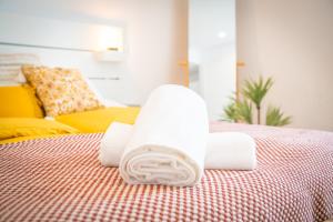 a stack of folded towels on a bed at Apartamento situado na zona costeira da cidade in Setúbal