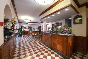 a lobby with a bar with a checkered floor at Hotel Acqui & Centro Benessere in Acqui Terme