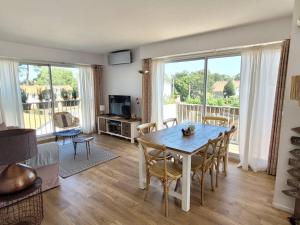 a dining room with a table and chairs in a living room at Havre de paix 4 étoiles, 2 pièces calme et lumineux à 100 mètres de la plage in Saint-Georges-de-Didonne