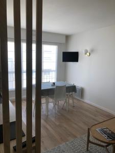 a living room with a dining room table with chairs at Charmant T2, hyper-centre, à 50m de la plage ! in Le Touquet-Paris-Plage