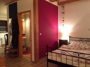 a bedroom with a bed with a purple wall at Ferienwohnungen "Vieling" Objekt-ID 12155-9 in Waren