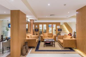 a living room filled with furniture and a large window at TUI Blue Gardens - Adults-only - Savoy Signature in Funchal