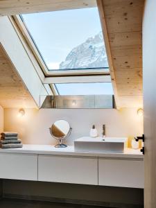 a bathroom with a sink and a skylight at Tempel 74 Apartments in Mellau