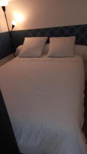 a bed with white sheets and pillows in a room at Vue mer port de garavan in Menton
