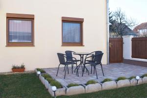 a patio with chairs and a table in a yard at Elixír Apartman in Villány
