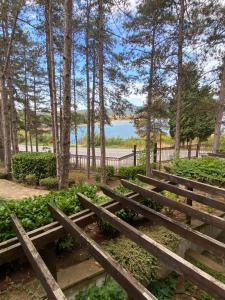 une rangée de bancs en bois dans un parc arboré dans l'établissement Tiny Bijou Sea View studio - Santa Marina - Sozopol, à Sozopol