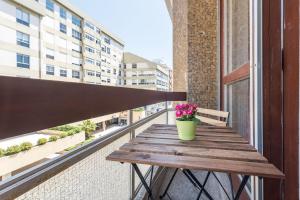 a wooden table on a balcony with a potted plant at GuestReady - The Happy Place in Porto in Porto