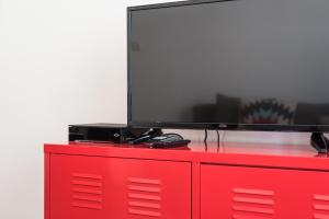 a red dresser with a television on top of it at GuestReady - The Happy Place in Porto in Porto