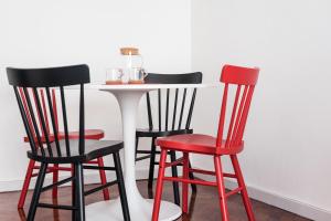 a white table with four red and black chairs at GuestReady - The Happy Place in Porto in Porto