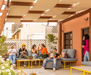 un grupo de personas sentadas en un patio en Intra Muros Hostel en Heraclión