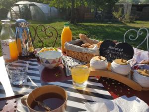 a picnic table with a basket of food and orange juice at LA ROULOTTE DES AMISH & Bain Nordique à Remous Jacuzzi in Mattexey